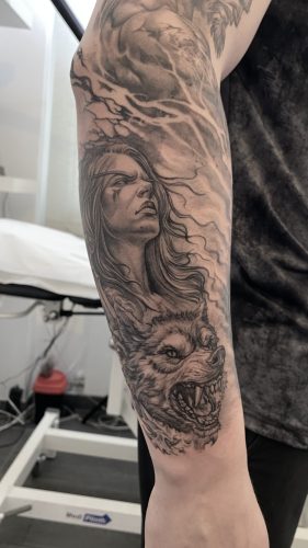 frau mit wolf tattoo unterarm München